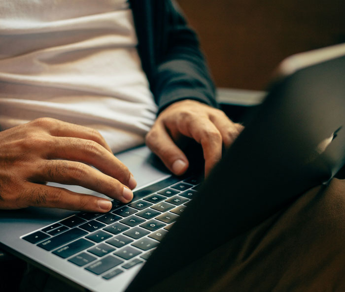 Person typing on a laptop, symbolizing effort and wealth despite minimal work.